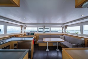 Een chalet met kitchenette, zithoek en grote ramen met uitzicht op het water.