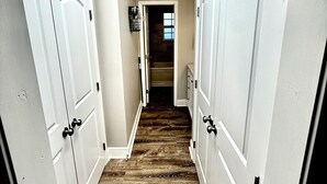 A narrow hallway with wooden flooring, white doors, and a skylight. - Duplex in the Caribbean Paradise (Panama City)