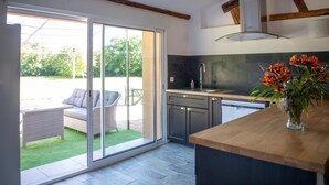 Une cuisine moderne dotée d’une grande porte-fenêtre coulissante qui donne sur un patio.
