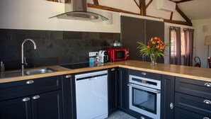 Une cuisine moderne équipée d’un lave-vaisselle, d’un four et d’un micro-ondes rouge.