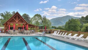 Eine Holzlodge mit Pool und Liegestühlen.