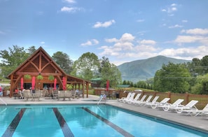 Eine Holzlodge mit Pool und Liegestühlen.