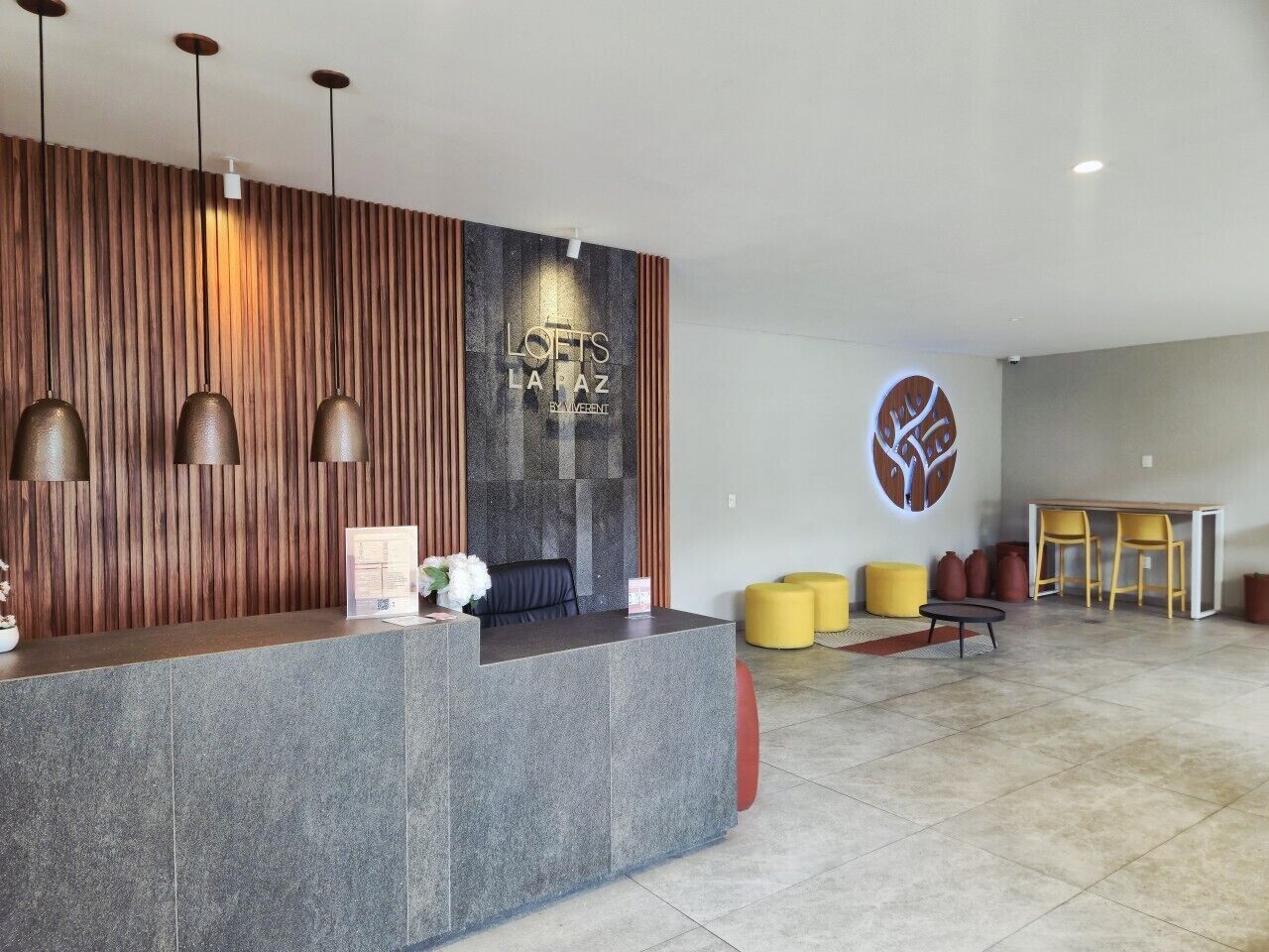 A reception area with a modern design, featuring a reception desk, seating area, and a decorative wall.
