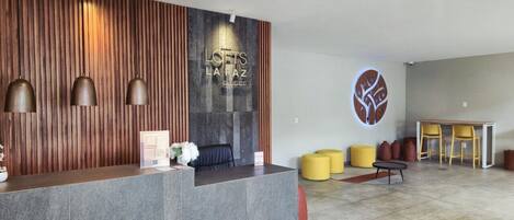 A reception area with a modern design, featuring a reception desk, seating area, and a decorative wall.