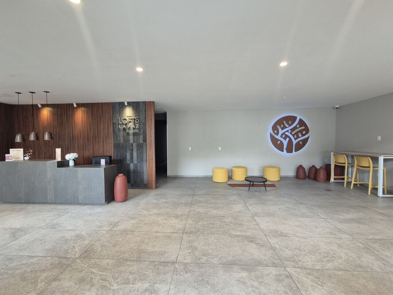 A spacious lobby with a reception desk, seating area, and a large wall mural.