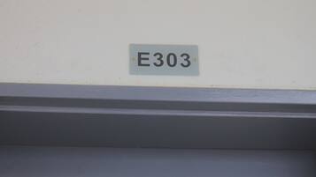 A sign with the number E303 on a wall.