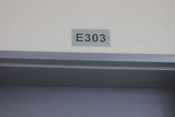 A sign with the number E303 on a wall.