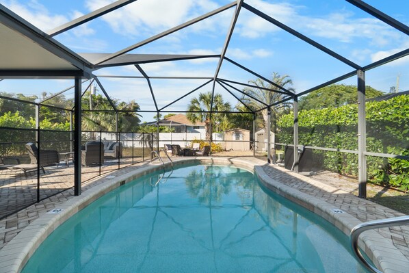 Piscina interna com vista desobstruída da área circundante, incluindo um pátio com mobiliário externo e vista do bairro.