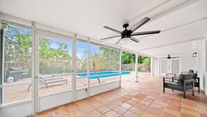 An open patio with a pool, ceiling fans, and outdoor furniture. - 114 Managed by Brampton Park (Delray Beach)