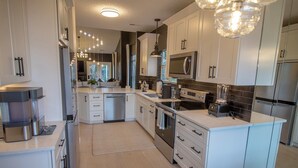 A modern kitchen with white cabinetry, stainless steel appliances, and a central island. - McConnell Golf Retreat Near Sedgefield Country Club (Greensboro)