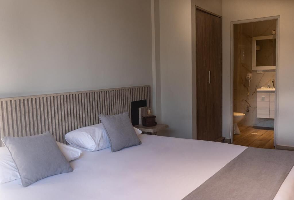 Ein Hotelzimmer mit einem großen Bett, einem Nachttisch und einem hölzernen Kopfteil.