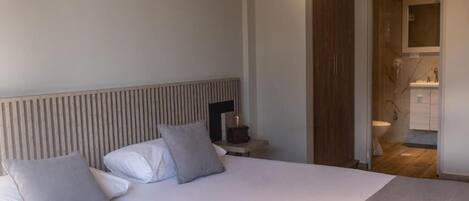 Ein Hotelzimmer mit einem großen Bett, einem Nachttisch und einem hölzernen Kopfteil.