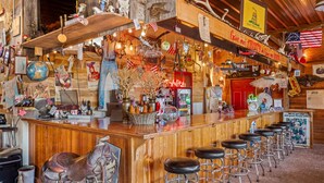 Een rustieke bar met houten planken, Amerikaanse vlaggen en diverse decoraties.