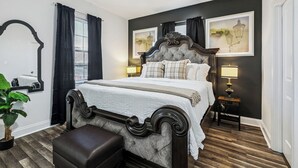 A bedroom with a large bed, dark wood headboard, and two bedside lamps.