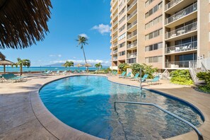 A swimming pool with lounge chairs and a view of the ocean. - SUMMER SALE! Cozy studio with ocean views and premium amenities - RK 1103 (Lahaina)