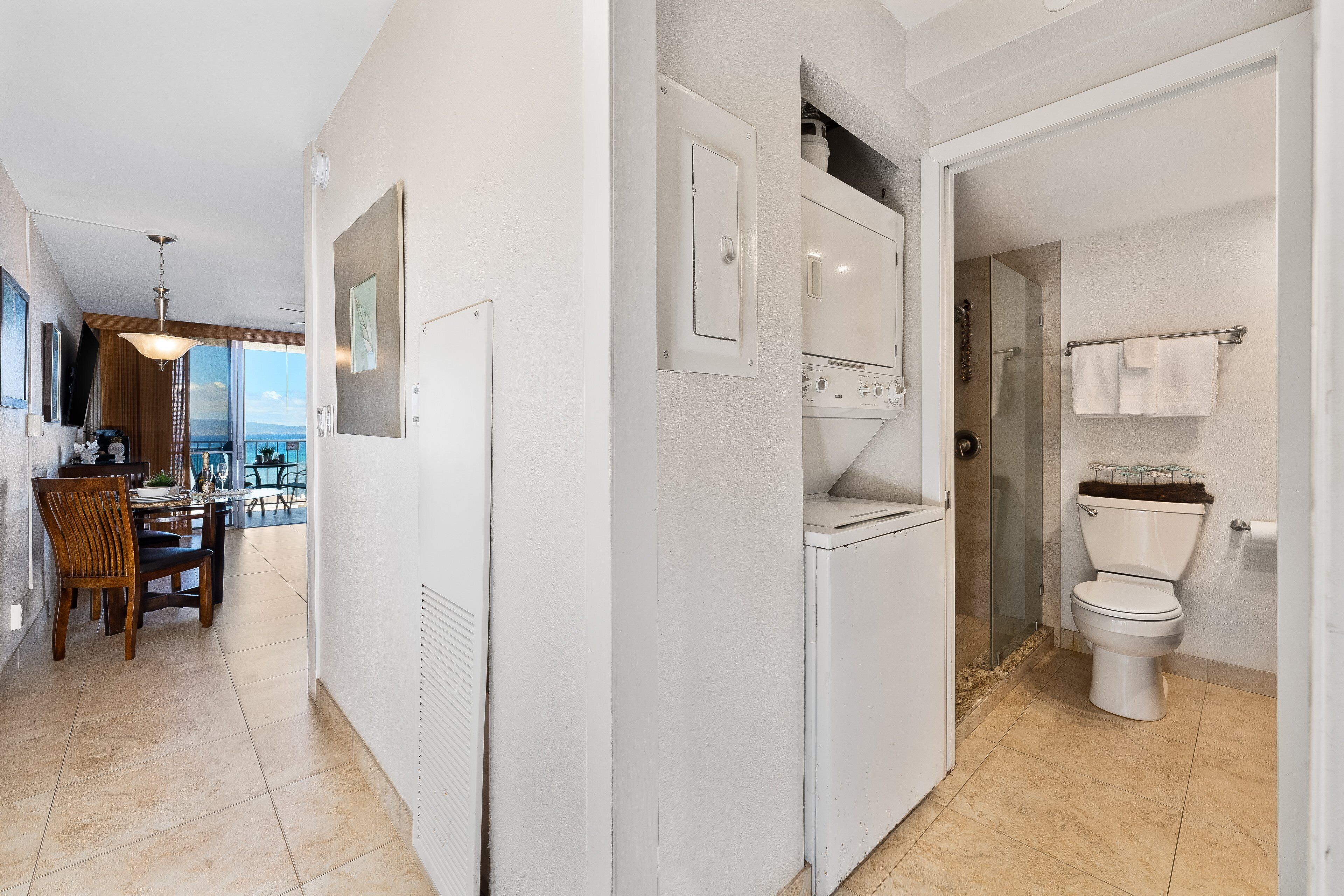 Un baño moderno con inodoro, ducha y zona de ducha con mampara de vidrio.