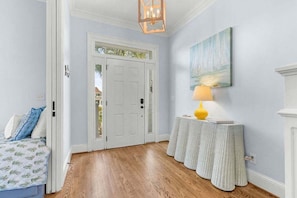 A hallway with a white door, a small table with a lamp, and a painting on the wall. - 4BR Oceanfront - Amazing Sunsets! Amenity Access incl. (Seabrook Island)