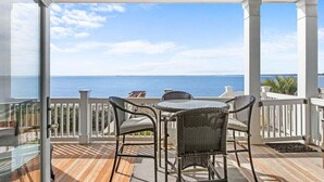 A covered outdoor area with a view of the sea, featuring a table and chairs. - 4BR Oceanfront - Amazing Sunsets! Amenity Access incl. (Seabrook Island)