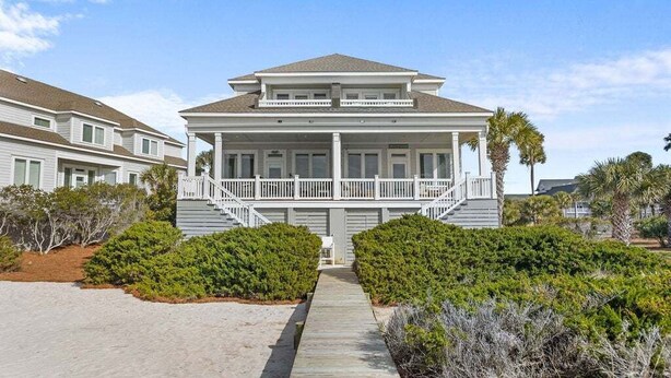 A two-story beachfront house with a covered porch and a staircase leading to the entrance. - 4BR Oceanfront - Amazing Sunsets! Amenity Access incl. (Seabrook Island)