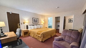 Une chambre d’hôtel comprenant un lit, des tables de chevet, un bureau, une chaise et un téléviseur.