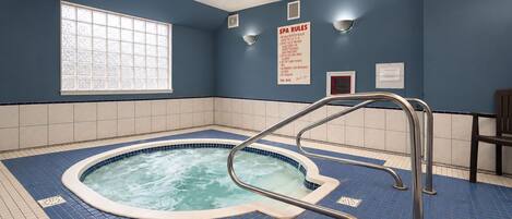 A spa room with a hot tub, a window, and a sign with spa rules.
