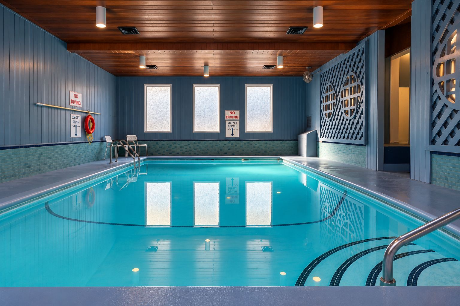 An indoor swimming pool with clear signage indicating no diving and a depth of 2m-7ft.