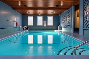 An indoor swimming pool with clear signage indicating no diving and a depth of 2m-7ft.