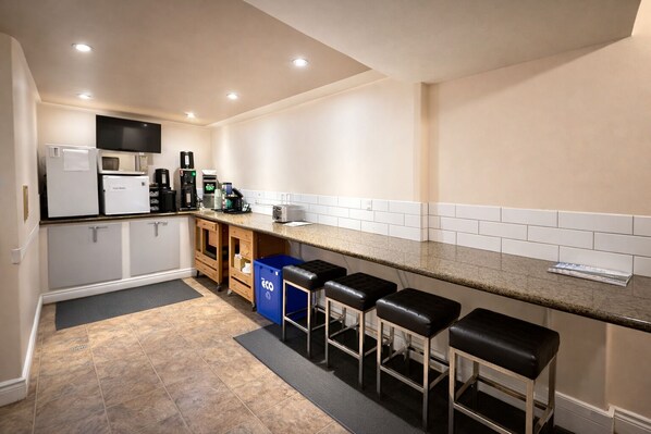A compact kitchen with a countertop, a refrigerator, a coffee maker, and a trash bin. - Rychter Hotel Hope (Hope)
