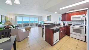 Un'ampia cucina con isola centrale, elettrodomestici moderni e vista sull'oceano.