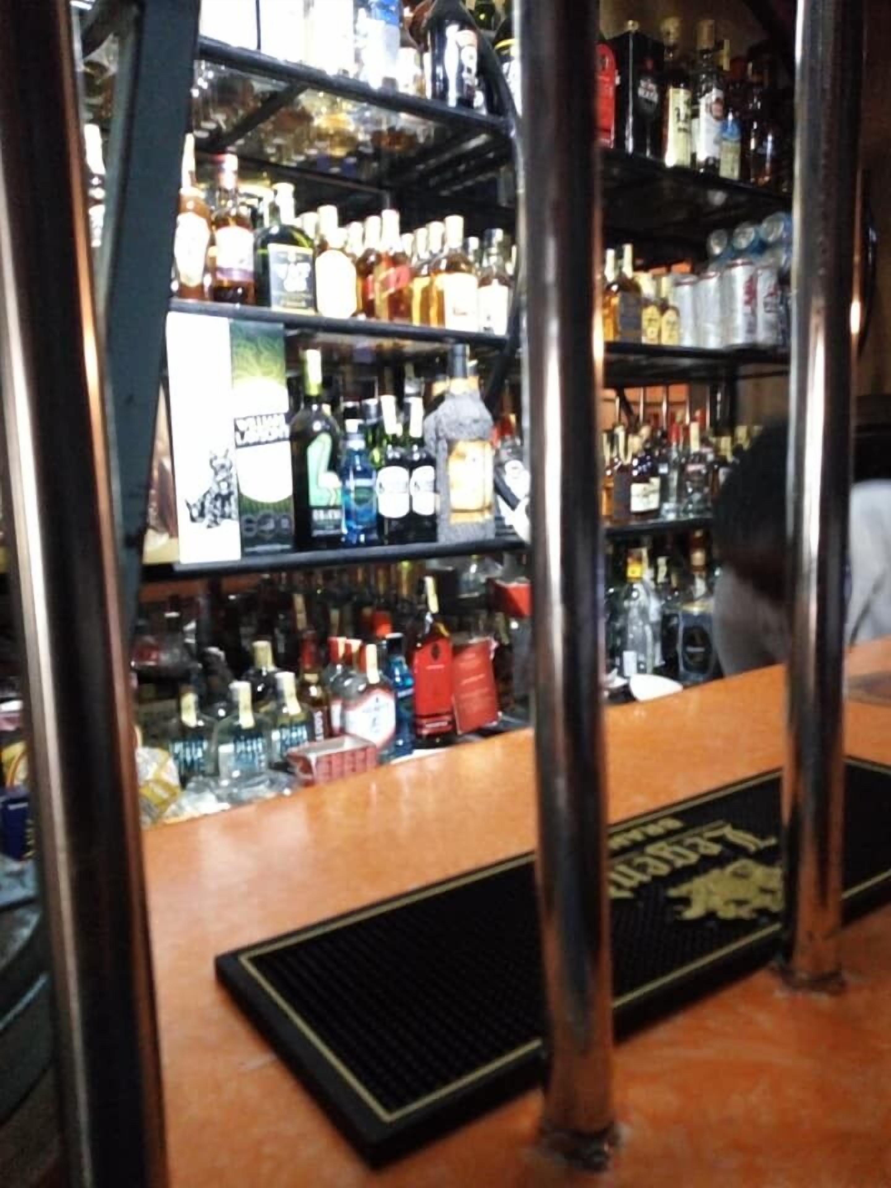 Un espace bar avec des étagères remplies de différentes bouteilles d’alcool.