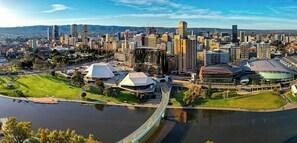 A cityscape with a prominent bridge, modern buildings, and a stadium. - KozyGuru | Joslin | Private Self-Contained 1 BR (Joslin)
