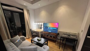 Ein modernes Wohnzimmer mit Sofa, Couchtisch, Fernseher und Essbereich.