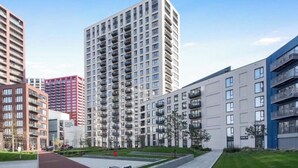Ein moderner Apartmentkomplex mit mehreren Hochhäusern, einem zentralen Innenhof und einer gepflegten Grünanlage.