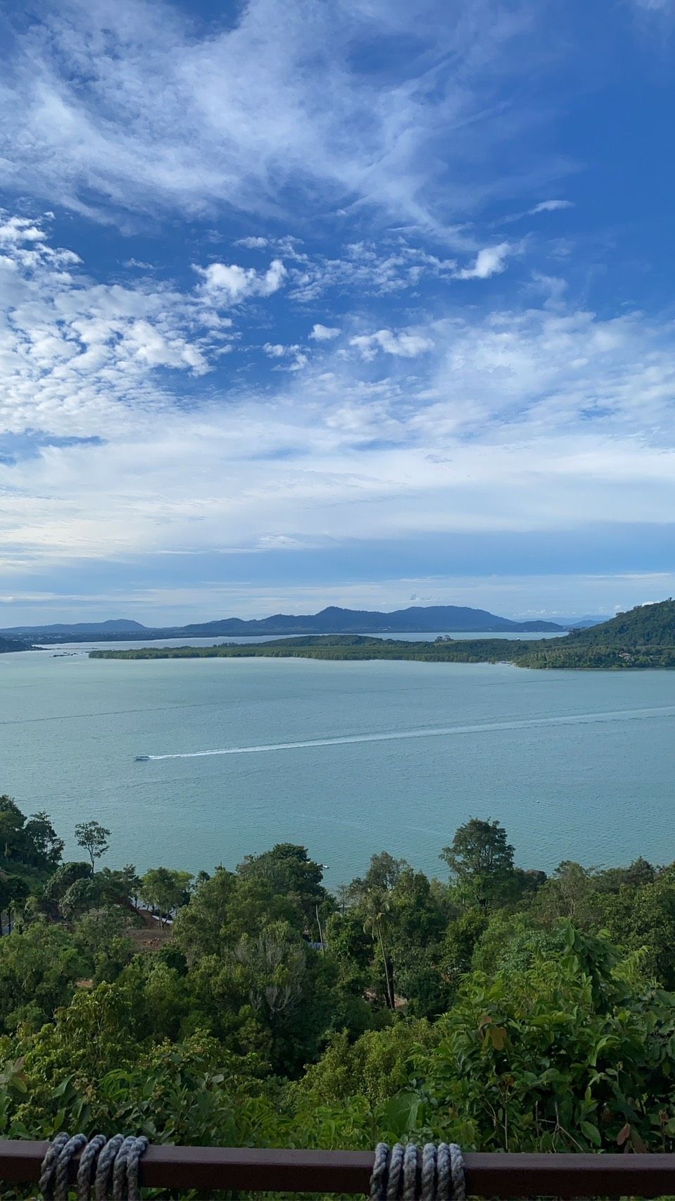 A panoramic view of a lake with surrounding hills and dense greenery.