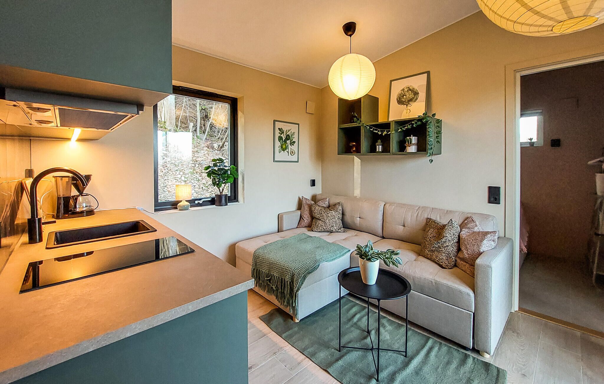 Una cocina moderna con un lavaplatos integrado y una ventana con vistas a un jardín.