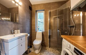 Un baño moderno con inodoro, lavamanos y ducha.