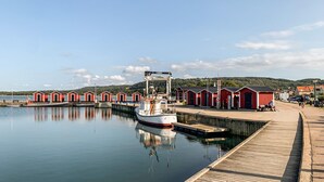 Un rivage paisible avec un quai, un bateau et des bâtiments rouges le long de la côte.
