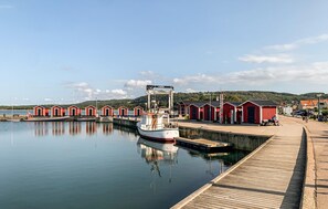 A calm waterfront with a dock, a boat, and red buildings along the shore. - Nice home in Båstad with WiFi (Båstad)