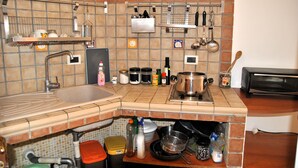 A kitchen with a sink, stove, and various utensils and containers.