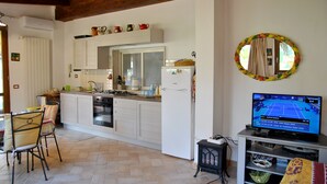 Una cocina con comedor, televisor y espejo.