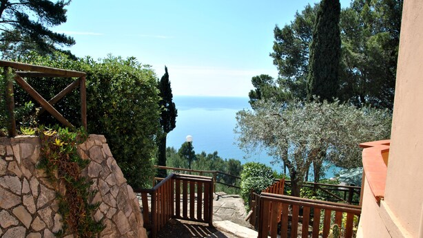 A stone staircase leading to a wooden gate with a view of the sea. - Casa Simon Nature and Sea (Sperlonga)