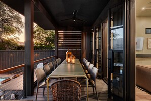 A covered outdoor dining area with a long table, chairs, and lanterns. - LGD Luxury Combo | Heated Pool & Hot Tub (New Orleans)
