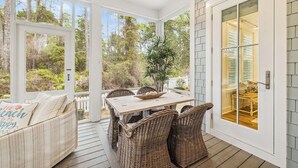 A covered porch with wicker furniture, a table with a bowl, and a view of the outdoors. - Watersound~ Golf Cart | Bikes | Gated Community | Private Beach Access (Santa Rosa Beach)