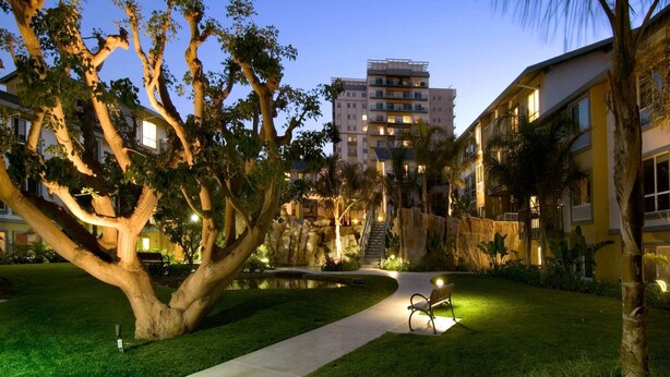 A well-lit courtyard with a large tree, a small pond, and a bench. - Blue Horizon' 3BD 2BA Full Ocean Views Panoramic Heaven Venice Beach (Marina del Rey)