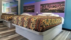 A hotel room with a large bed, a cityscape mural on the wall, and a modern design.