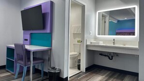 A bathroom with a vanity, mirror, and a toilet.