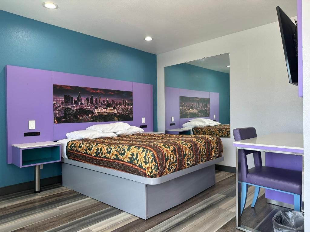 A hotel room with two beds, a desk, and a chair.