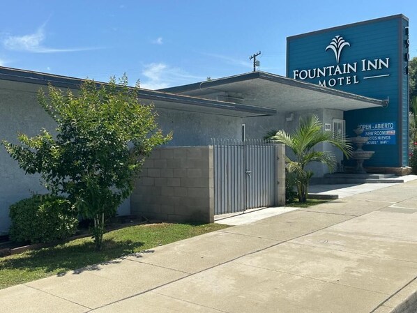 A Fountain Inn Motel with a large sign, a gated entrance, and a small tree in the foreground. - Fountain Inn Motel - Alhambra, Los Angeles (Alhambra)