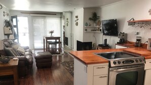 A modern kitchen with a stainless steel stove, wooden countertops, and a dining area with a table and chairs. - Perfectly located Extra large 1-bedroom condo in central Aspen (Aspen)
