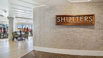 A Shutters Lounge with a textured wall and a signboard.